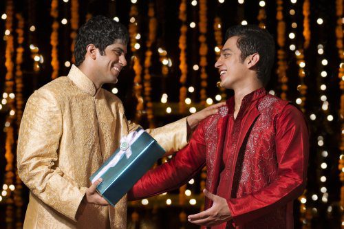 A young man presenting an awesome diwali gift for his friend