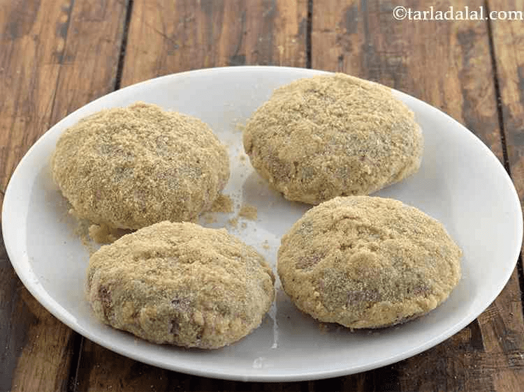 Baby spinach cutlets after being coated in breadcrumbs