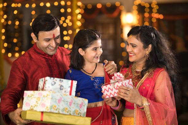 An Indian family holding Diwali boxes