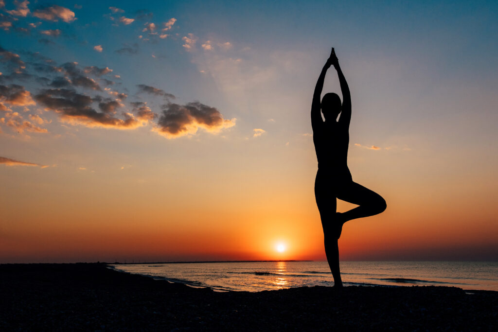 A girl doing yoga at beach